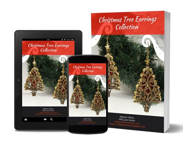 Photo of brass filigree Christmas tree earrings on an i-Pad, cell phone and book cover