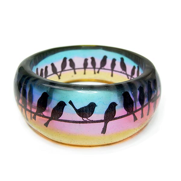 Resin bangle with birds on a telegraph wire silhouetted against a gradient sunset