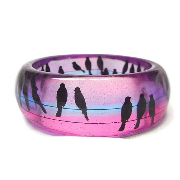 Colour gradient in a resin bangle featuring silhouetted birds on a wire