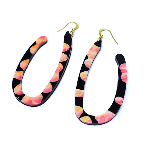 Resin statement earrings featuring pink and orange abstract splodges on a black base
