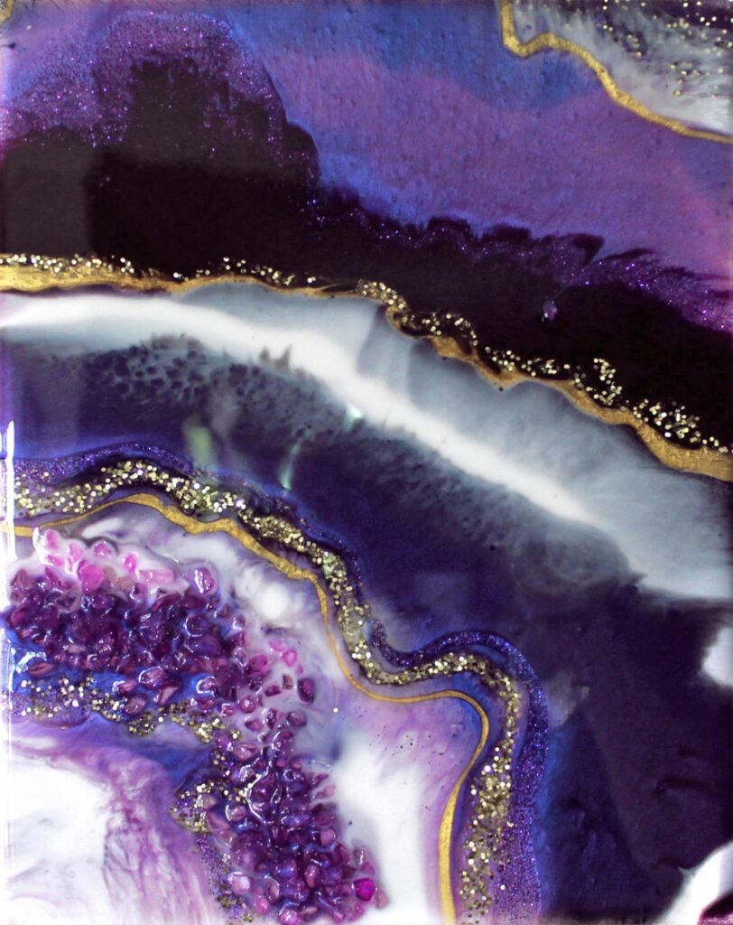 Resin geode painting with purple, white and gold bands of colour, highlighted with gold glitter and purple crushed glass