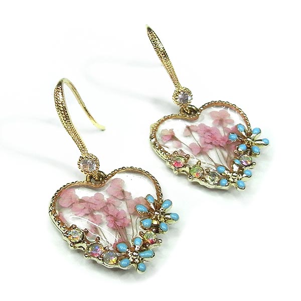 Heart shaped resin earrings filled with delicate pink flowers in a gold frame decorated with blue enamel daisies